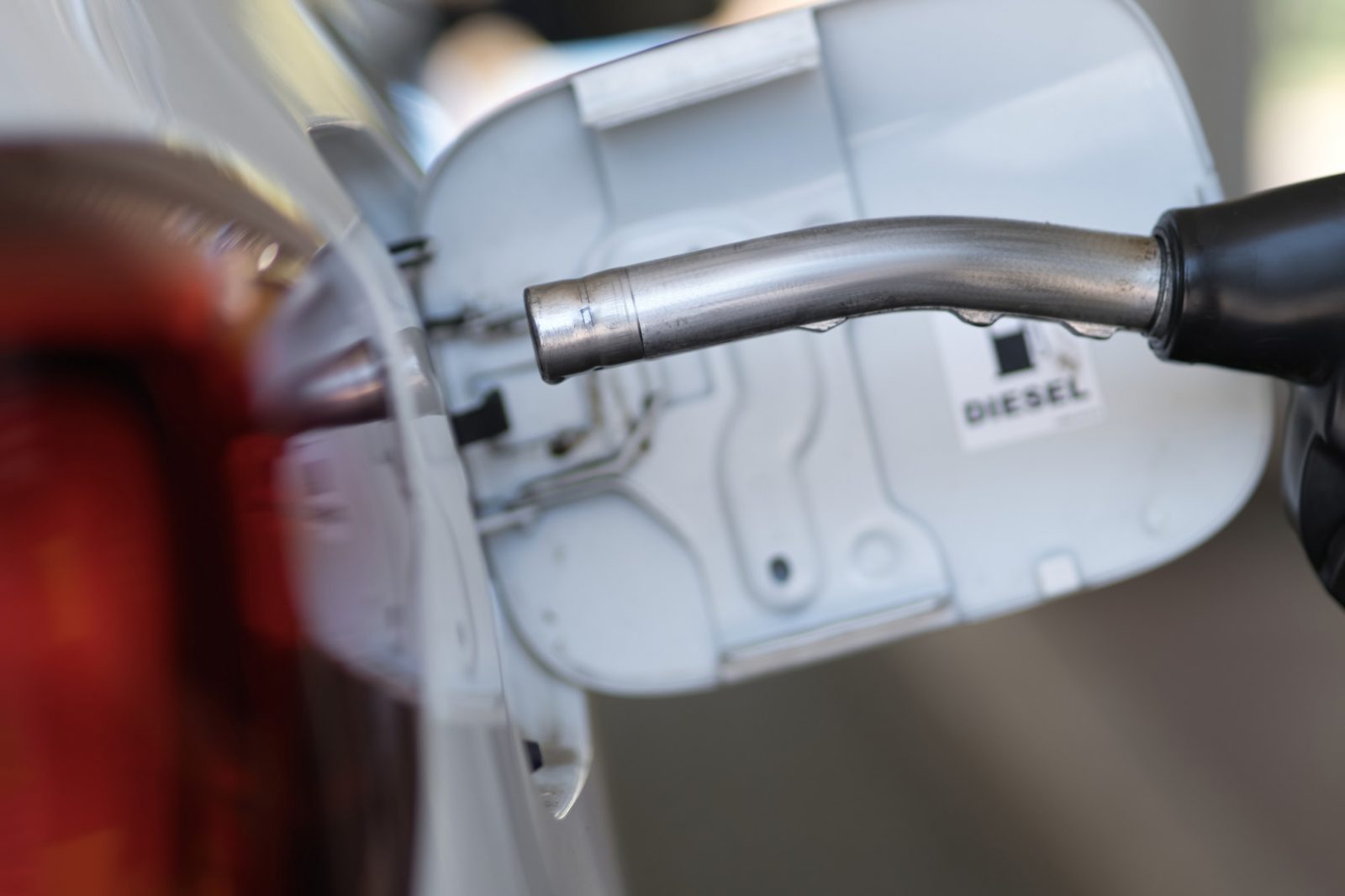 Petrol pump filling fuel nozzle in fuel tank of car at gas station